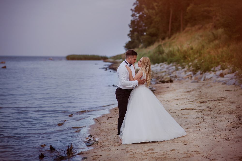 fotografia pary młodej w objęciach nad brzegiem